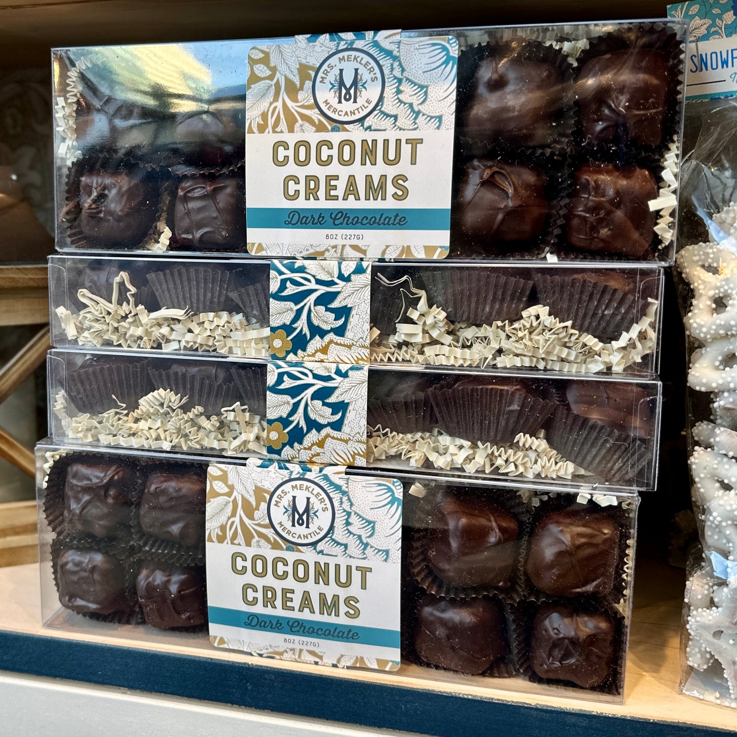 Boxes of dark chocolate coconut cream candies stacked on a shelf
